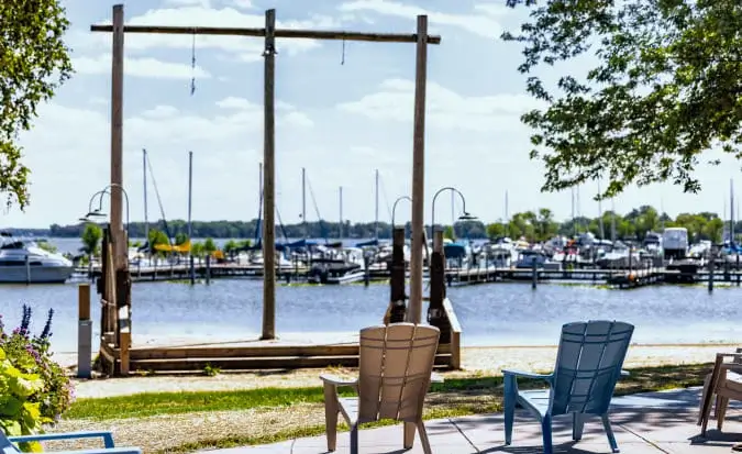 A chair on a sidewalk by a body of water